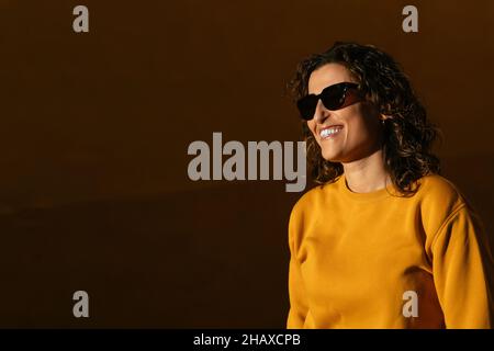 Stylish woman in sunglasses standing on street Stock Photo