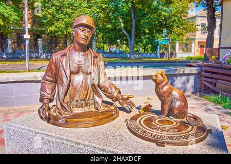 POLTAVA, UKRAINE - AUGUST 22, 2021: The unusual sculpture to a plumber and a cat located in Solnechny Park, on August 22 in Poltava Stock Photo