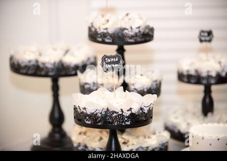 Black ast iron ornate cupcake towers with vanilla cupcakes that have chocolate fuge drizzle Stock Photo
