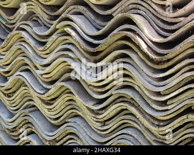 Textured wavy sheets of slate, close up. Old roofing slates storage. Corrugated asbestos-cement sheets Stock Photo