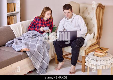 An IT specialist sets up remote desktop on laptop of an employee who works from home. Stock Photo