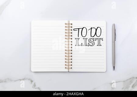 To do list for next year. Empty notebook on white table with silver pen. Top view Stock Photo