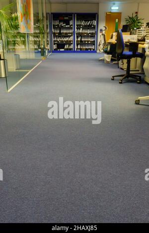 view along the room of desks, chairs, screens and filing cabinets in an empty open-plan office Stock Photo