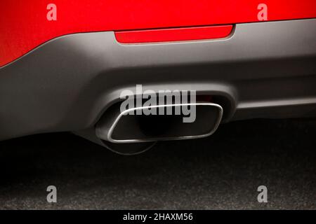 Part of a red car. Car exhaust pipe. Close up. Stock Photo