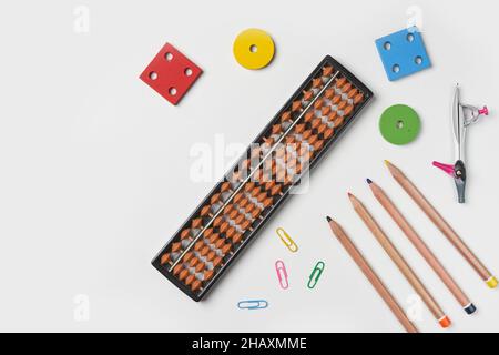 Creative lay out of mental mathematics items. Mental arithmetic for kids. School items for kids. Abacus with school supplies, drawing compass on Stock Photo