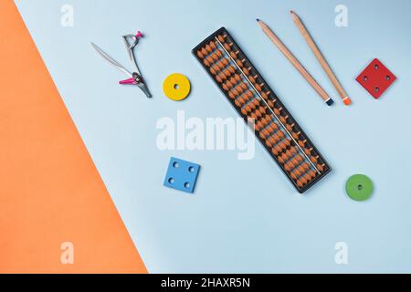Creative lay out of mental mathematics items. Mental arithmetic for kids. School items for kids. Abacus with school supplies, drawing compass on Stock Photo