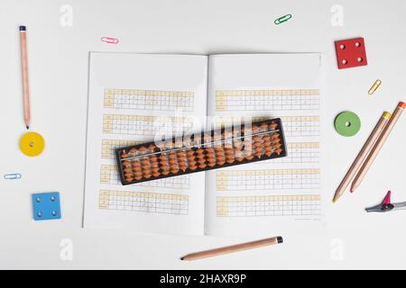 Creative lay out of mental mathematics items. Mental arithmetic for kids. School items for kids. Abacus with school supplies, drawing compass on Stock Photo
