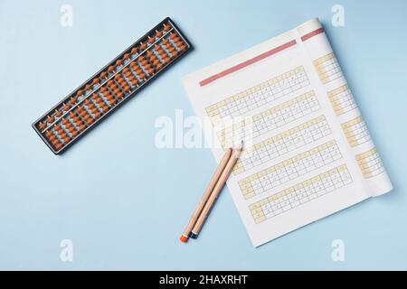 Creative lay out of mental mathematics items. Mental arithmetic for kids. School items for kids. Abacus with school supplies, drawing compass on Stock Photo