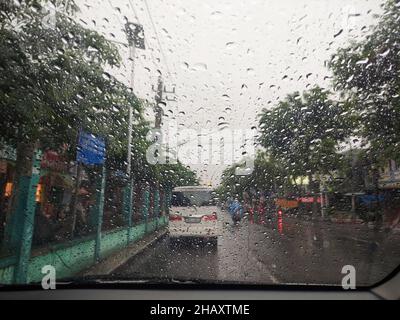 raindrops on the car window with a cloudy sky in the afternoon.  taking photos from inside the car Stock Photo