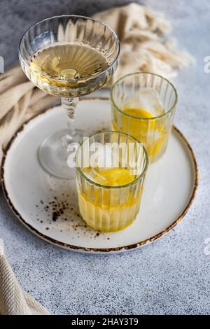 Two glasses of vodka cocktails with lemon and ice cubes on a table Stock Photo