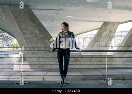Portrait of a cool Asian gothic woman standing on a bridge Stock Photo