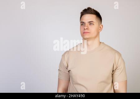 Handsome young man with stylish hairstyle looking at camera with serious expression. Photo of young attractive handsome modern freelancer Stock Photo