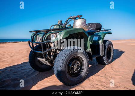 Four wheeler quadbike on sand at beach on bright sunny day Stock Photo