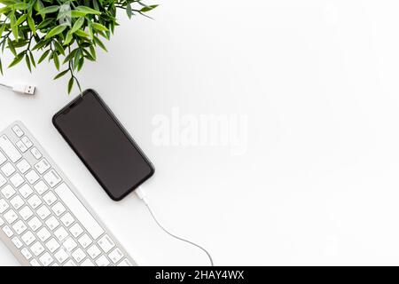 Cables for charging smartphone or laptop on office table, top view Stock Photo