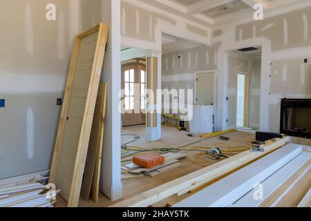 View of on stacker wooden material door molding trim with new house of under construction Stock Photo