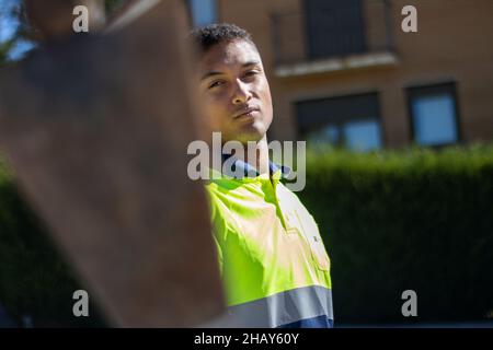 Close-up shot of a worker in reflective uniform looking at the camera Stock Photo