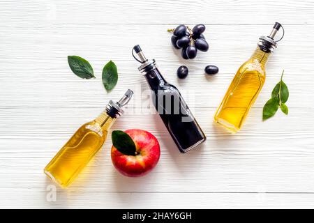 Apple cider and balsamic vinegar in bottles with grapes and red apples Stock Photo