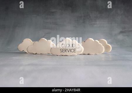 Cloud computing concept. White clouds with text CLOUD SERVICE. Stock Photo