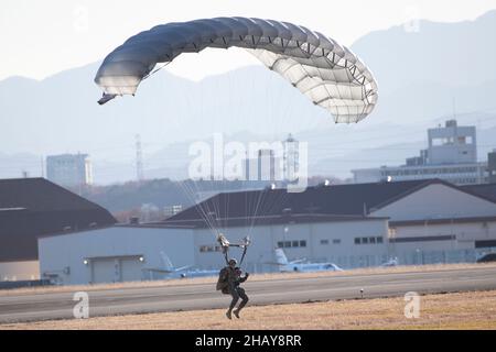 A Marine assigned to the 3rd Reconnaissance Battalion, 3rd Marine Division, lands on a drop zone during a high altitude, low opening (HALO) parachute training at Yokota Air Base, Japan, Dec. 13, 2021. U.S. Marines and a U.S. Air Force Survival, Evasion, Resistance and Escape (SERE) specialist conducted week-long jump training using Air Force and Navy aircraft. The training supports the U.S. Indo-Pacific Command’s dynamic force employment (DFE) concept through agile combat employment (ACE), which supports the National Defense Strategy effort to conduct training with joint partners while maintai Stock Photo