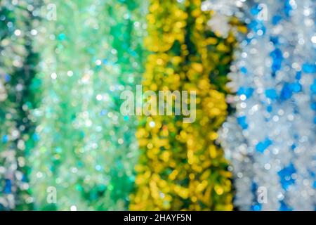 Defocused image of multicolored shiny Christmas tinsel. Background festive picture. Fullscreen photo. Bokeh optical effect Stock Photo