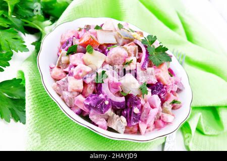 Finnish Rosoli salad with herring, beetroot, potatoes, pickled or pickled cucumbers, carrots, onions and eggs, dressed with mayonnaise in a bowl again Stock Photo