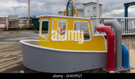 Outdoor playground for children with ships. Small ships or boats for children in a playground in a city. Street view, selective focus, nobody. Stock Photo