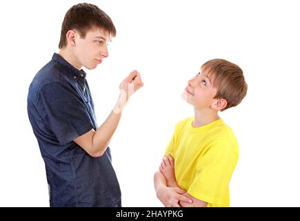 Teenager threaten a Naughty Kid with a Fist on the White Background Stock Photo