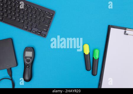 Office Workplace with Digital Gadgets Lying on Blue Table - Flat Lay Stock Photo