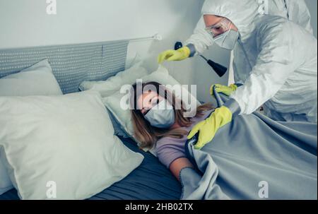 Doctors in bacteriological protective suits caring for a patient Stock Photo