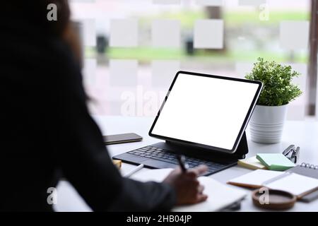 Rear view businesswoman using computer tablet in office. Stock Photo