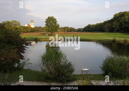 View across the Castle Blutenburg pond with the Parish Church of the Passion of Christ in the background, Munich,Bavaria,Germany. Stock Photo
