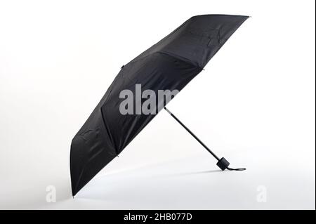 Opened black umbrella isolated on white background. Studio shoot Stock Photo