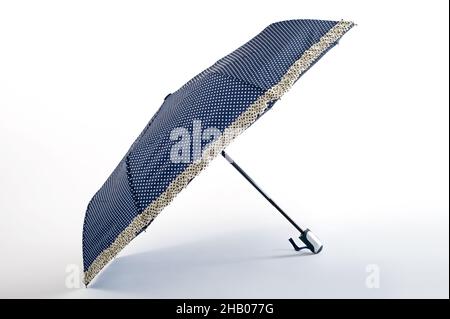 Opened blue dot umbrella isolated on white background. Studio shoot Stock Photo