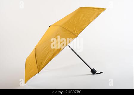 Opened yellow umbrella isolated on white background. Studio shoot Stock Photo