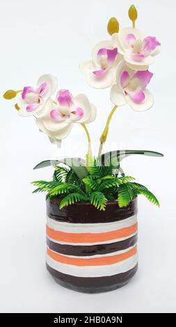 Artificial orchid with ornamental ceramic vase isolated on white background Stock Photo