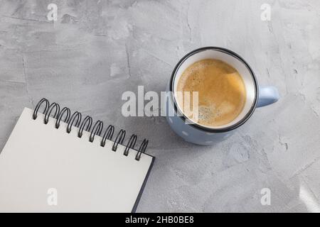 Mockup. Open sketchpad or notebook on artist desk workspace, coffee in blue retro style ceramic cup on gray background. Creative concept, empty page. Top view, copy space Stock Photo