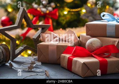 Gifts and a wooden star on a Christmas background. Side view, close-up. Stock Photo