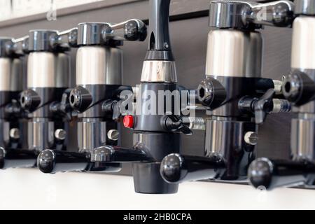 Beer taps for draught drinks are built into wooden boards in pub Stock Photo