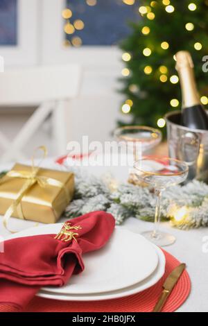 Christmas festive table setting, red towel with gold ring. Family holiday dinner or night New Year party. Vertical format. Close up. Stock Photo