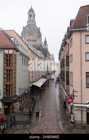 Dresden, Germany. 16th Dec, 2021. Passers-by walk along Münzgasse in front of the Frauenkirche. Credit: Sebastian Kahnert/dpa-Zentralbild/dpa/Alamy Live News Stock Photo