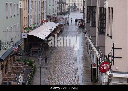 Dresden, Germany. 16th Dec, 2021. Passers-by walk along the empty Münzgasse. Credit: Sebastian Kahnert/dpa-Zentralbild/dpa/Alamy Live News Stock Photo