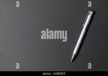 Elegant and luxury metal ballpoint pen on black stone background Stock Photo