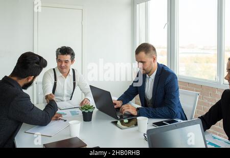 Young business people working and communicating while sitting at the office desk together with colleagues sitting. business meeting Stock Photo