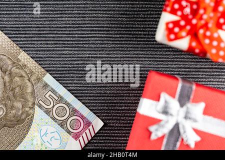 Polish 500PLN  banknote with presents arranged on a gray background. Small boxes with bows. Photo taken under artificial, soft light Stock Photo
