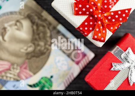 Polish 500PLN  banknote with presents arranged on a gray background. Small boxes with bows. Photo taken under artificial, soft light Stock Photo