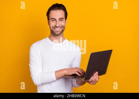 Photo of ceo brunet young guy write laptop wear white outfit isolated on vibrant yellow color background Stock Photo