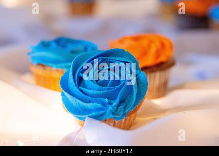 Blue and orange cupcakes on table with bokeh background Stock Photo
