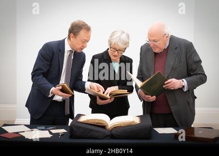 (left to right) Newspaper editor and Chairman of the Friends of the National Libraries (FNL), Geordie Grieg, Professor Kathryn Sutherland, Unversity of Oxford, and Charles Sebag-Montefiore, Treasurer FNL, look at books and manuscripts which form part of Honresfield Library collection, on display at Sotheby's in London, after the collection was saved for the nation following fundraising of over £15 million by FNL. The sale of the library was announced in 2021 and FNL were able to purchase the entire collection outright on behalf of appropriate recipient libraries within the UK. Picture date: Th Stock Photo