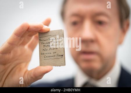 Newspaper editor and Chairman of the Friends of the national Libraries, Geordie Grieg holds one of Charlotte Bronte's 'little books, which forms part of the Honresfield Library collection, on display at Sotheby's in London, after the collection of manuscripts and printed books were saved for the nation following fundraising of over £15 million by Friends of the National Libraries (FNL). Picture date: Thursday December 16, 2021. Stock Photo