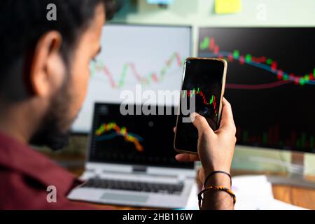selective focus on hand, trader watching stock market candlestick patterns - concept of Investing money on shares using technical analysis, trading or Stock Photo